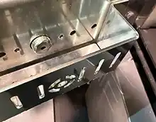 MARELI SYSTEM / CALDAIA LEGNA LCG LAMBDA – Dettaglio sistema accensione automatica: l’immagina illustra lo sportello su sui è montato un piccolo contenitore al cui interno viene messo del pellet che servirà come innesco per l'accensione automatica della combustibile, L'accensione del pellet avviene per surriscaldamento a mezzo di una candeletta, la stessa che normalmente viene utilizzata nelle stufe e/o delle caldaie a pellet.